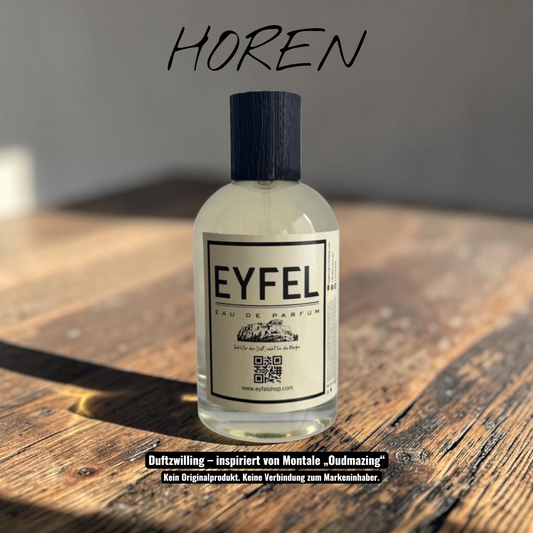eyfel Horen Eau de Parfum mit Oud-Duftnote in einer eleganten 100ml Glasflasche neben der weißen und gelben Verpackung